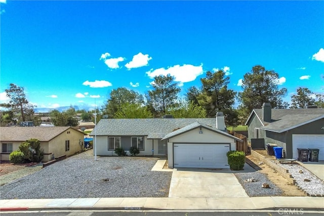single story home with concrete driveway and an attached garage