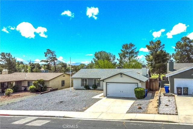 single story home featuring a garage, stucco siding, and driveway