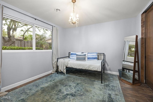 bedroom with dark wood finished floors, baseboards, a notable chandelier, and multiple windows
