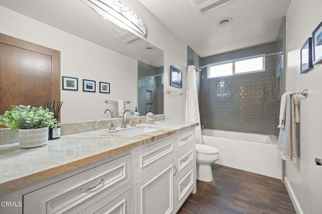 bathroom with visible vents, shower / tub combo with curtain, toilet, wood finished floors, and vanity