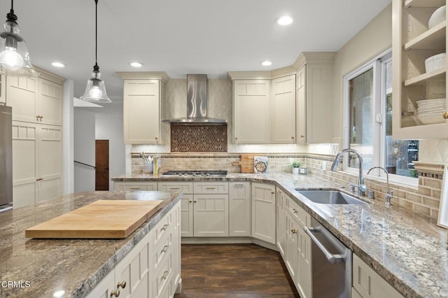 kitchen with appliances with stainless steel finishes, a sink, recessed lighting, and wall chimney exhaust hood