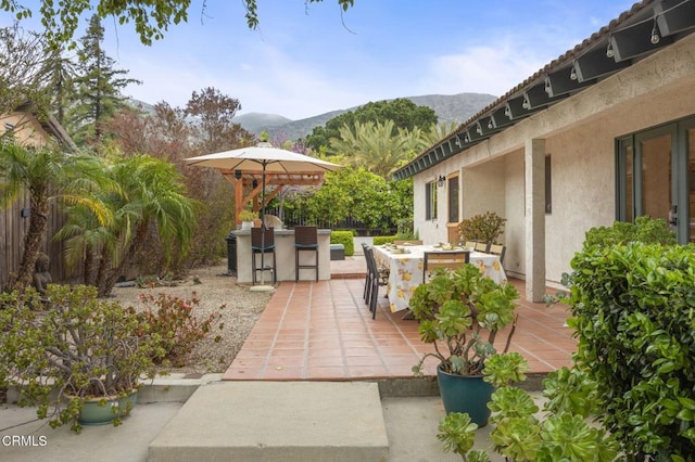 view of patio featuring outdoor dry bar, a mountain view, and outdoor dining area