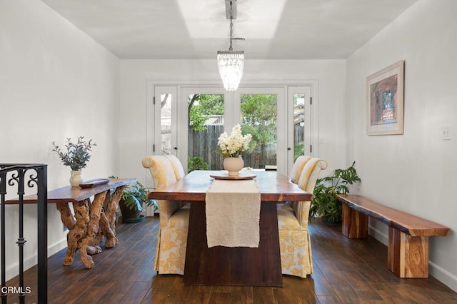 dining room featuring dark wood-style floors, an inviting chandelier, and baseboards