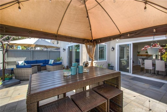 view of patio / terrace featuring a gazebo, fence, outdoor dining space, and outdoor lounge area