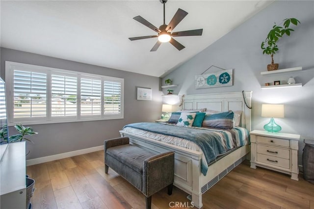 bedroom featuring lofted ceiling, baseboards, wood finished floors, and ceiling fan