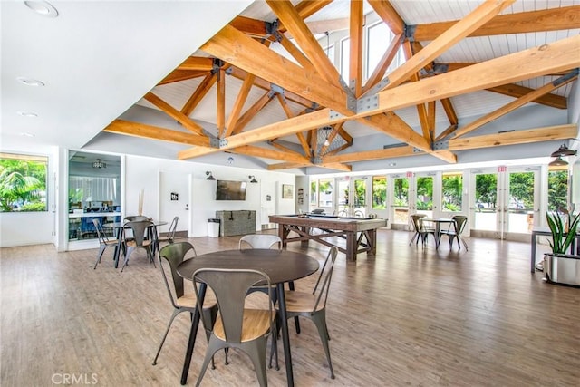 dining space featuring french doors, high vaulted ceiling, light wood-style flooring, and a healthy amount of sunlight