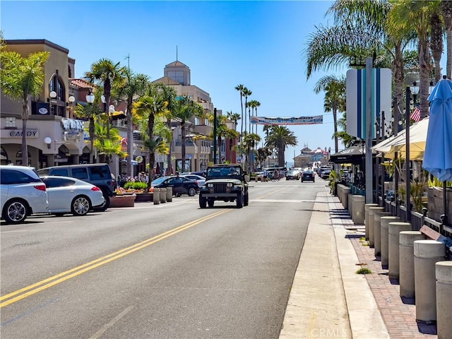 view of road featuring sidewalks, curbs, and street lighting