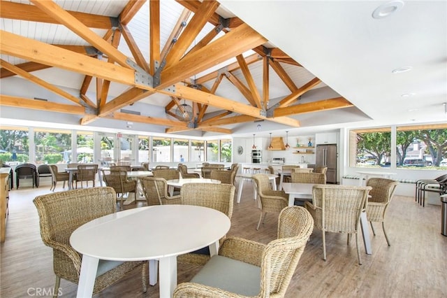 dining space featuring recessed lighting, light wood-style flooring, and high vaulted ceiling