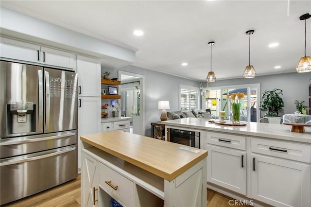 kitchen with butcher block counters, light wood-style floors, white cabinetry, and stainless steel fridge with ice dispenser