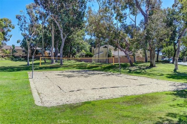 view of community with volleyball court, fence, and a yard