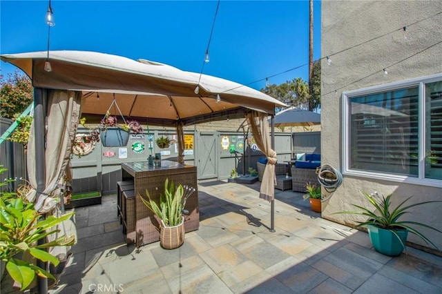 view of patio / terrace with fence, an outdoor hangout area, and a gazebo