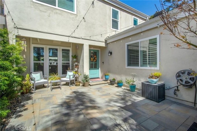 rear view of house featuring a patio area and stucco siding