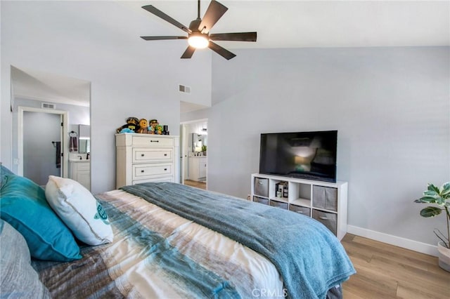 bedroom with baseboards, light wood-style flooring, visible vents, and high vaulted ceiling