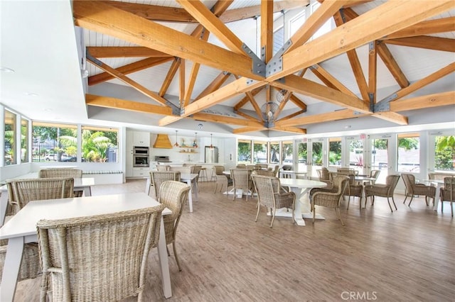 interior space featuring beamed ceiling, plenty of natural light, high vaulted ceiling, and light wood-style flooring
