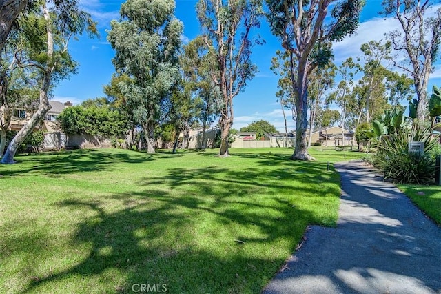 view of property's community with fence and a lawn