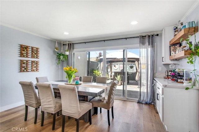 dining room with baseboards, recessed lighting, ornamental molding, and light wood-type flooring