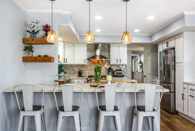 kitchen featuring wall chimney range hood, open shelves, stainless steel appliances, backsplash, and a peninsula