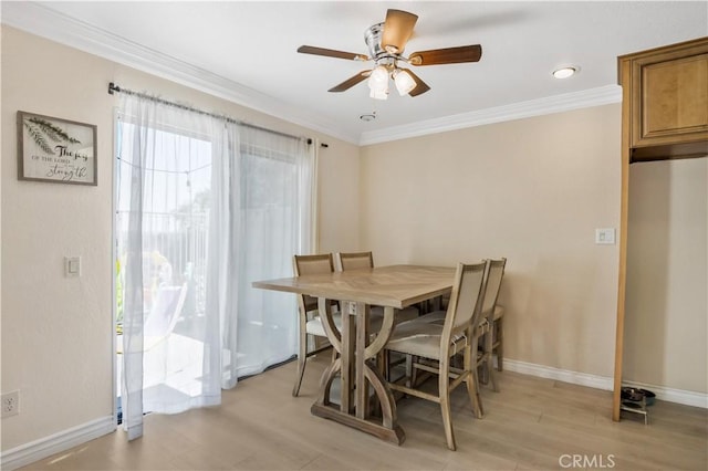 dining area with crown molding, light wood-style floors, a ceiling fan, and baseboards