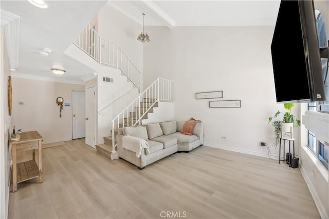 living room featuring stairway, visible vents, light wood-type flooring, crown molding, and baseboards