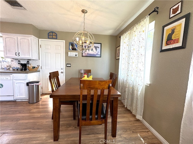 1120 S Yorktown St, Ridgecrest, CA 93555 - dining space featuring a chandelier, healthy amount of natural light, and dark wood-type flooring
