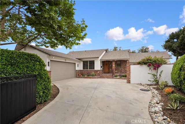 ranch-style house with concrete driveway, a shingled roof, fence, a garage, and stucco siding