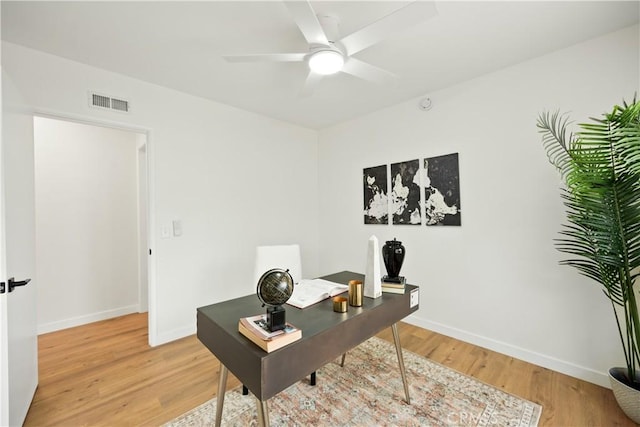 office area featuring light wood finished floors, baseboards, a ceiling fan, and visible vents