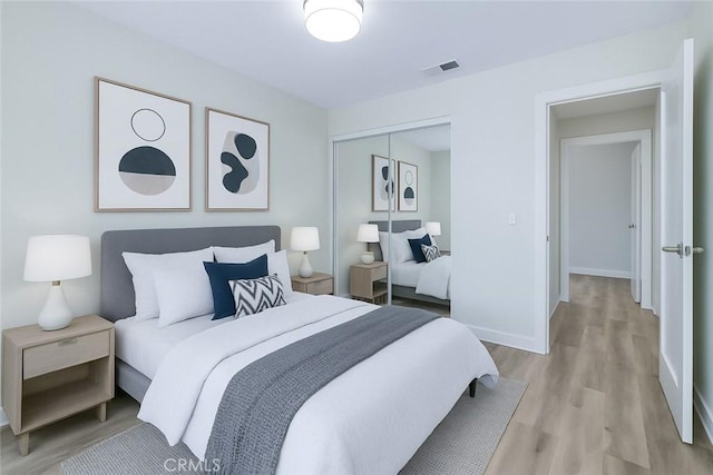 bedroom with a closet, light wood-style flooring, visible vents, and baseboards