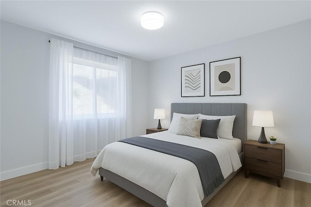 bedroom with baseboards and light wood-type flooring