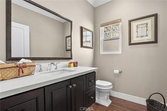 bathroom with baseboards, wood finished floors, toilet, and vanity