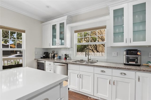 kitchen featuring a sink, decorative backsplash, crown molding, white cabinets, and beverage cooler