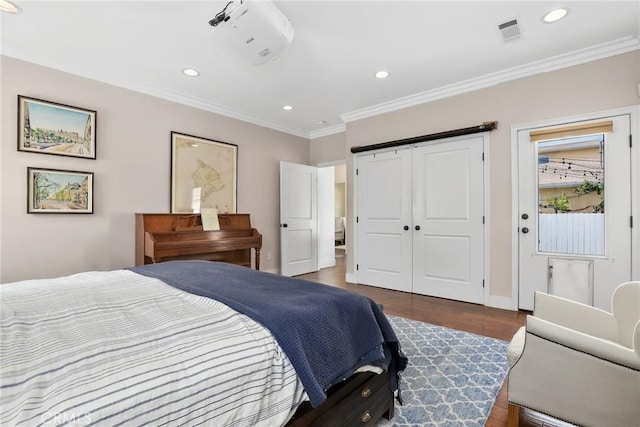 bedroom with recessed lighting, ornamental molding, wood finished floors, baseboards, and a closet