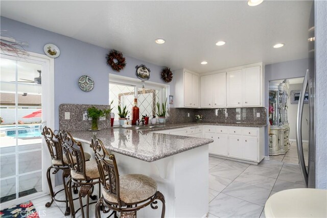 917 Brandywine Ln, Corona, CA 92880 - kitchen featuring a peninsula, white cabinetry, tasteful backsplash, a sink, and recessed lighting