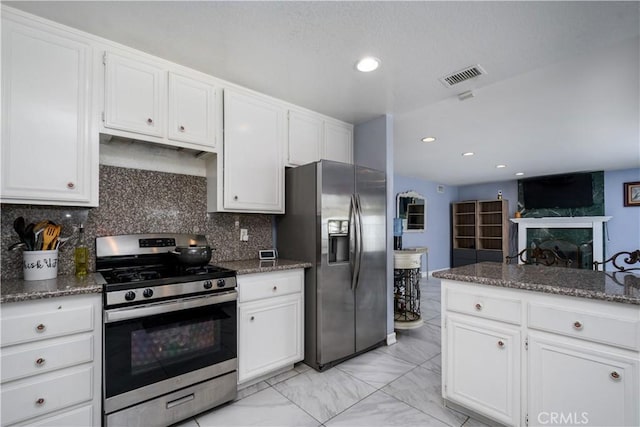 917 Brandywine Ln, Corona, CA 92880 - kitchen featuring appliances with stainless steel finishes, white cabinetry, light marble finish flooring, dark stone counters, and backsplash