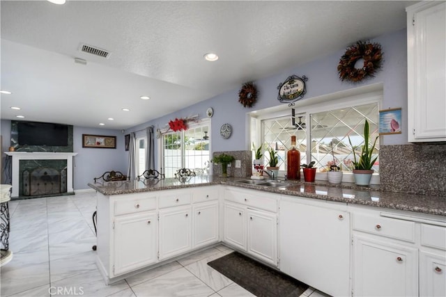917 Brandywine Ln, Corona, CA 92880 - kitchen with a sink, a high end fireplace, white cabinetry, light marble finish floors, and dark stone counters