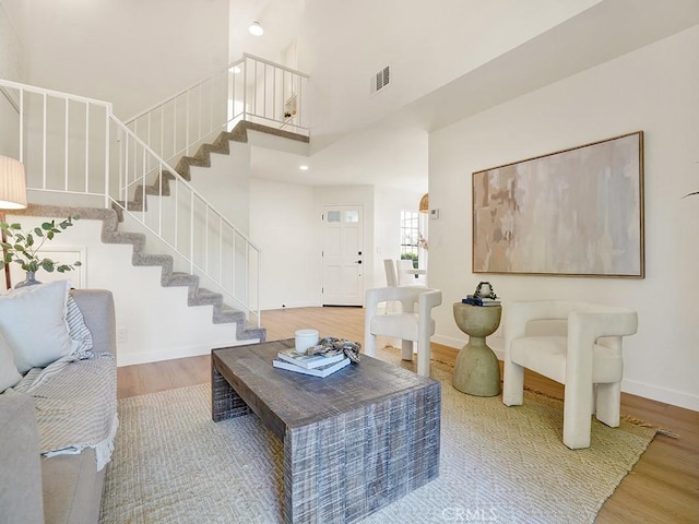 2720 E Walnut Ave Unit 10, Orange, CA 92867 - living room with stairway, wood finished floors, a towering ceiling, and baseboards
