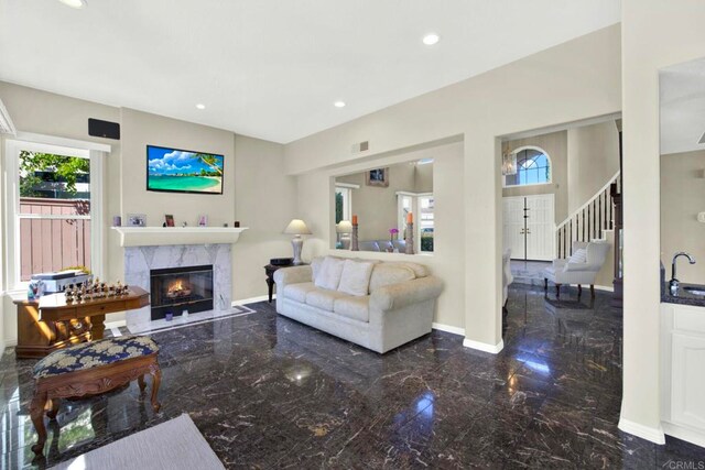 14082 Montfort Ct, San Diego, CA 92128 - living area with marble tiled floors, a high end fireplace, stairs, and recessed lighting
