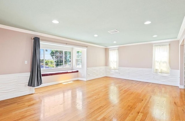 interior space with recessed lighting, wood finished floors, a healthy amount of sunlight, and ornamental molding