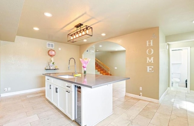 kitchen with arched walkways, visible vents, recessed lighting, and a sink