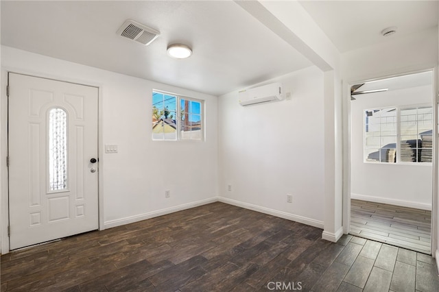 entryway with a wall mounted air conditioner, dark wood-style floors, baseboards, and visible vents