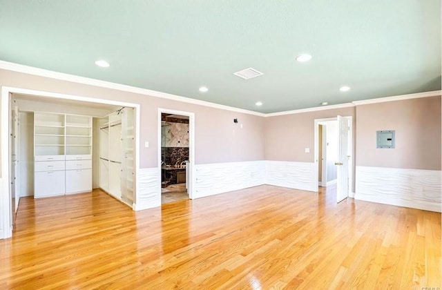 interior space with wainscoting, light wood-style flooring, recessed lighting, and crown molding