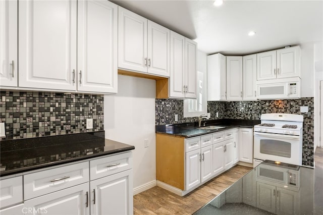 kitchen with light wood-style flooring, a sink, tasteful backsplash, white cabinetry, and white appliances