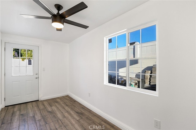 unfurnished room featuring baseboards, a ceiling fan, and wood finished floors