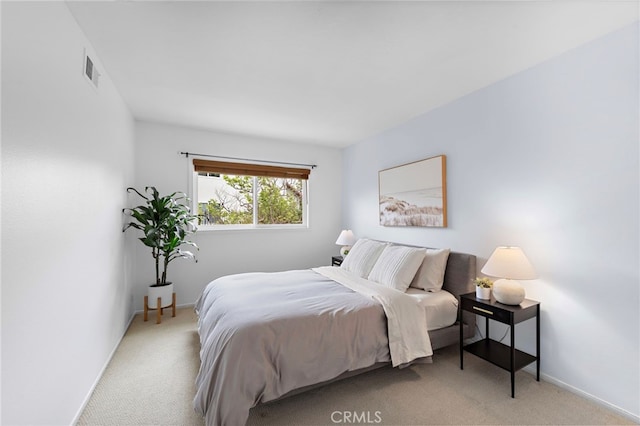 bedroom with light carpet, visible vents, and baseboards