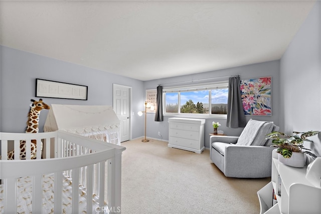 carpeted bedroom featuring baseboards and a nursery area