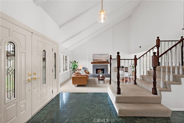 entrance foyer with high vaulted ceiling, beam ceiling, a stone fireplace, and stairway