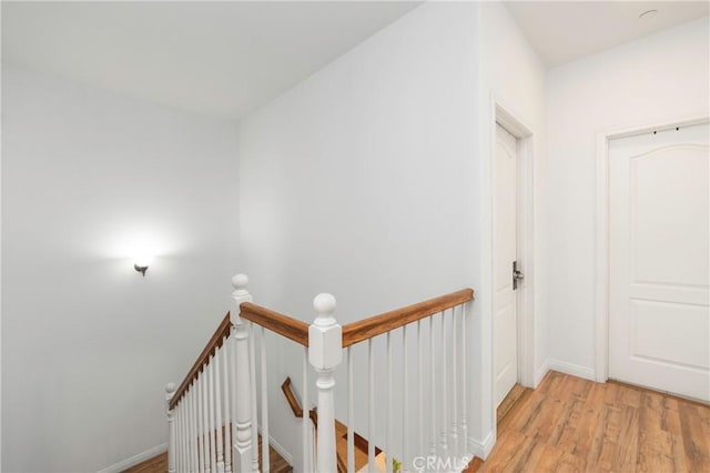 6651 Darling Ln, San Bernardino, CA 92407 - hall with baseboards, light wood finished floors, and an upstairs landing