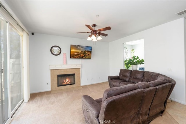 6651 Darling Ln, San Bernardino, CA 92407 - living room featuring light colored carpet, visible vents, ceiling fan, baseboards, and a tile fireplace