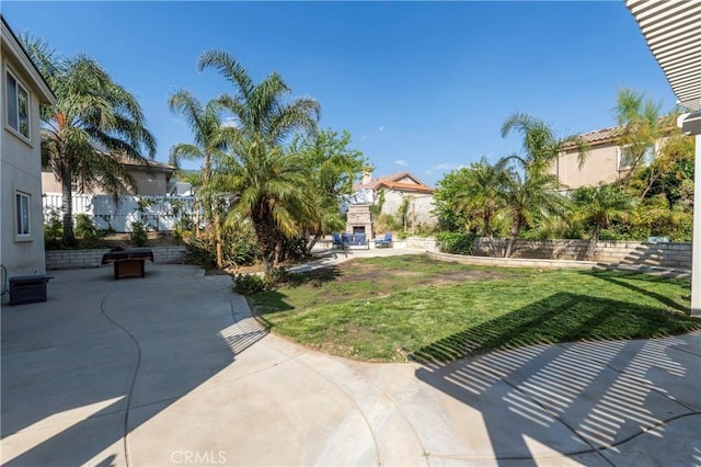 6651 Darling Ln, San Bernardino, CA 92407 - view of yard featuring a patio area, an outdoor stone fireplace, and fence