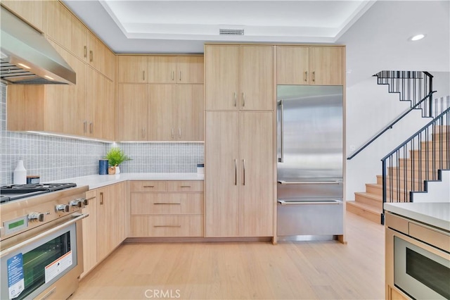 3202 Green Ln, Redondo Beach, CA 90278 - kitchen with under cabinet range hood, light brown cabinetry, a tray ceiling, and high end appliances