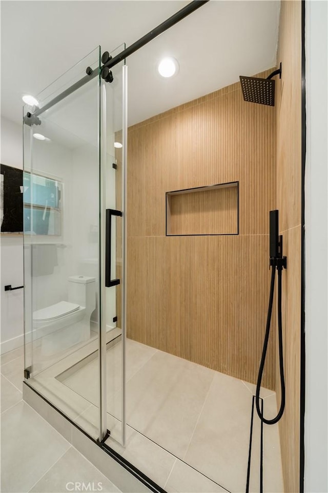 full bath featuring tile patterned floors, a shower stall, and toilet